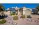 Tan house with solar panels and drought-tolerant landscaping at 4952 E Princess Dr, Mesa, AZ 85205