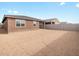 A view of the backyard showing the home's exterior and privacy fence and ready for landscaping at 16025 W Cottontail Ln, Surprise, AZ 85387