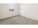 This bedroom features neutral carpeting and natural light from the window at 16025 W Cottontail Ln, Surprise, AZ 85387