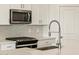 Close up of kitchen details like a gas range, quartz countertops, and stainless steel appliances at 16025 W Cottontail Ln, Surprise, AZ 85387