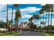 Elegant community entrance with lush landscaping and towering palm trees under a sunny, blue sky at 2550 S Ellsworth Rd # 215, Mesa, AZ 85209