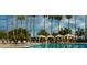 Serene pool area with comfortable seating under cabanas, surrounded by swaying palm trees and lush greenery at 2550 S Ellsworth Rd # 215, Mesa, AZ 85209