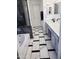 Bright bathroom featuring a double sink vanity, modern tub, and stylish black and white flooring at 4313 E Desert Trumpet Rd, Phoenix, AZ 85044