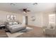 Spacious bedroom with carpeted floor, ceiling fan, and ensuite bathroom at 8143 E Obispo Ave, Mesa, AZ 85212