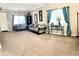 Bright living room with neutral carpet, stylish gray sofas, and large windows with blue curtains at 901 W Witt Ave, Queen Creek, AZ 85140