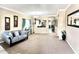 Spacious living room with a large mirror, plush carpeting, gray sofa, and views into the dining area at 901 W Witt Ave, Queen Creek, AZ 85140