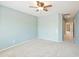 Bright bedroom featuring neutral carpet, ceiling fan, and access to the en-suite bathroom at 13668 W Figueroa Dr, Sun City West, AZ 85375