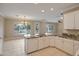 Open kitchen with granite countertops, white cabinetry, and a view of the landscaped backyard at 13668 W Figueroa Dr, Sun City West, AZ 85375
