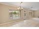 Living room showcasing a decorative light fixture and large windows overlooking the landscaped backyard at 13668 W Figueroa Dr, Sun City West, AZ 85375