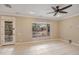 Bright living room featuring a ceiling fan, a large window, and a glass door at 13668 W Figueroa Dr, Sun City West, AZ 85375