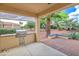 Outdoor kitchen with BBQ and lovely lush green backyard at 13668 W Figueroa Dr, Sun City West, AZ 85375