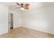 Bright bedroom featuring neutral carpeting, a ceiling fan, and an open doorway at 7752 W Mary Jane Ln, Peoria, AZ 85382
