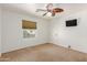 Bright bedroom featuring neutral carpeting, ceiling fan, and a window at 7752 W Mary Jane Ln, Peoria, AZ 85382