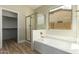 Bathroom features a tub, a glass shower, a walk-in closet, and a large window at 2156 E Aloe Pl, Chandler, AZ 85286