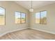 Bright and airy bedroom featuring hardwood floors, natural light from dual windows, and modern light fixture at 2156 E Aloe Pl, Chandler, AZ 85286