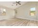 Neutral bedroom showcasing vinyl floors, baseboards, three windows, vaulted ceiling and ceiling fan at 2156 E Aloe Pl, Chandler, AZ 85286