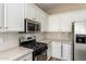 Updated kitchen has stainless appliances, white cabinets, gas cooktop, and light countertops at 2156 E Aloe Pl, Chandler, AZ 85286