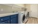 Laundry room features a front loading washer and dryer and blue cabinets at 2156 E Aloe Pl, Chandler, AZ 85286
