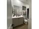 Bathroom with a large mirror over the vanity with sink and toilet with a window bringing in natural light at 6437 N 17 St, Phoenix, AZ 85016
