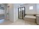 Bright bathroom features a glass shower, a soaking tub, and a white tiled floor at 6437 N 17 St, Phoenix, AZ 85016
