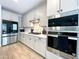 Close up of the modern stainless steel appliances and white cabinetry of this well-appointed kitchen at 6437 N 17 St, Phoenix, AZ 85016