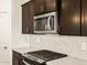 Modern kitchen with stainless steel appliances and white backsplash at 16006 W Cottontail Ln, Surprise, AZ 85387