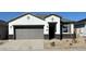 New two-story home with gray garage door and landscaping at 39980 W Agave Rd, Maricopa, AZ 85138