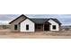 A charming single-story home featuring a combination of white and tan siding with sleek, dark-framed windows and a covered entryway at 1716 W Lucky Ln, Queen Creek, AZ 85144