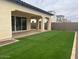 This backyard features an inviting covered patio and lush artificial turf for easy care at 2134 W Rowel Rd, Phoenix, AZ 85085