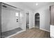 A modern bathroom features a glass enclosed walk-in shower, and arched entry to the walk-in closet at 2134 W Rowel Rd, Phoenix, AZ 85085