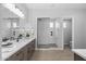 Bright bathroom featuring double vanity sinks, tile flooring, and modern glass enclosed shower at 2134 W Rowel Rd, Phoenix, AZ 85085
