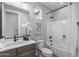 Stylish bathroom featuring a vanity with dark fixtures, white countertops, and a bathtub with shower and floral accents at 2134 W Rowel Rd, Phoenix, AZ 85085