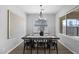 A modern dining room features wood floors, a stylish chandelier, and is decorated with a large painting at 2134 W Rowel Rd, Phoenix, AZ 85085