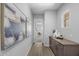 Hallway featuring wood-look flooring, neutral walls, contemporary artwork, and storage cabinets at 2134 W Rowel Rd, Phoenix, AZ 85085