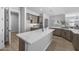 Modern kitchen features a large island with white countertop, wood-look flooring, and stainless steel appliances at 2134 W Rowel Rd, Phoenix, AZ 85085