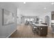 Open-concept living space with a modern kitchen island with seating overlooking a spacious living area with natural light at 2134 W Rowel Rd, Phoenix, AZ 85085