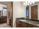 Well-lit bathroom with granite countertops, wood cabinets, and access to another bathroom at 9216 E Sky Line Dr, Scottsdale, AZ 85262