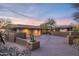 Beautiful home exterior with a spacious driveway, desert landscaping, and a two-car garage under a colorful sky at 9216 E Sky Line Dr, Scottsdale, AZ 85262