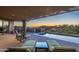 Outdoor patio with comfortable lounge chairs, built-in grill, pool, and desert views at 9216 E Sky Line Dr, Scottsdale, AZ 85262