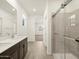 Bathroom with double vanity, walk in shower, and view to bedroom at 16014 W Cottontail Ln, Surprise, AZ 85387