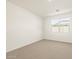Spacious bedroom with neutral carpeting and large window at 16014 W Cottontail Ln, Surprise, AZ 85387