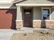 Front entry of home with brown door and stone accents at 16014 W Cottontail Ln, Surprise, AZ 85387