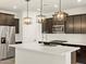 Modern kitchen with white quartz countertops and dark brown cabinets at 16014 W Cottontail Ln, Surprise, AZ 85387