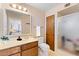 Bathroom with wooden cabinets, a frosted glass shower, and a large mirror reflecting the bedroom at 4019 E Calypso Ave, Mesa, AZ 85206