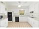 Well-lit kitchen with white cabinetry, black appliances, and a window overlooking a lush green space at 4019 E Calypso Ave, Mesa, AZ 85206