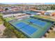 Overhead shot of tennis courts in a vibrant community surrounded by lush greenery and clear blue sky at 4019 E Calypso Ave, Mesa, AZ 85206