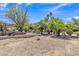 Extensive backyard with a covered deck, garden beds, mature trees, and gravel ground cover at 4222 E Brown Rd # 31, Mesa, AZ 85205
