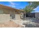 Backyard with a neutral tone wall with various equipment next to a dark fenced gate and brick ground at 4222 E Brown Rd # 31, Mesa, AZ 85205