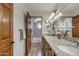 Bright bathroom showcasing granite countertops, double sinks, wood cabinets, and decorative tile in the shower at 4222 E Brown Rd # 31, Mesa, AZ 85205