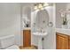 Half-bathroom with pedestal sink, custom storage, decorative mirror and lighting, and tiled floors at 4222 E Brown Rd # 31, Mesa, AZ 85205
